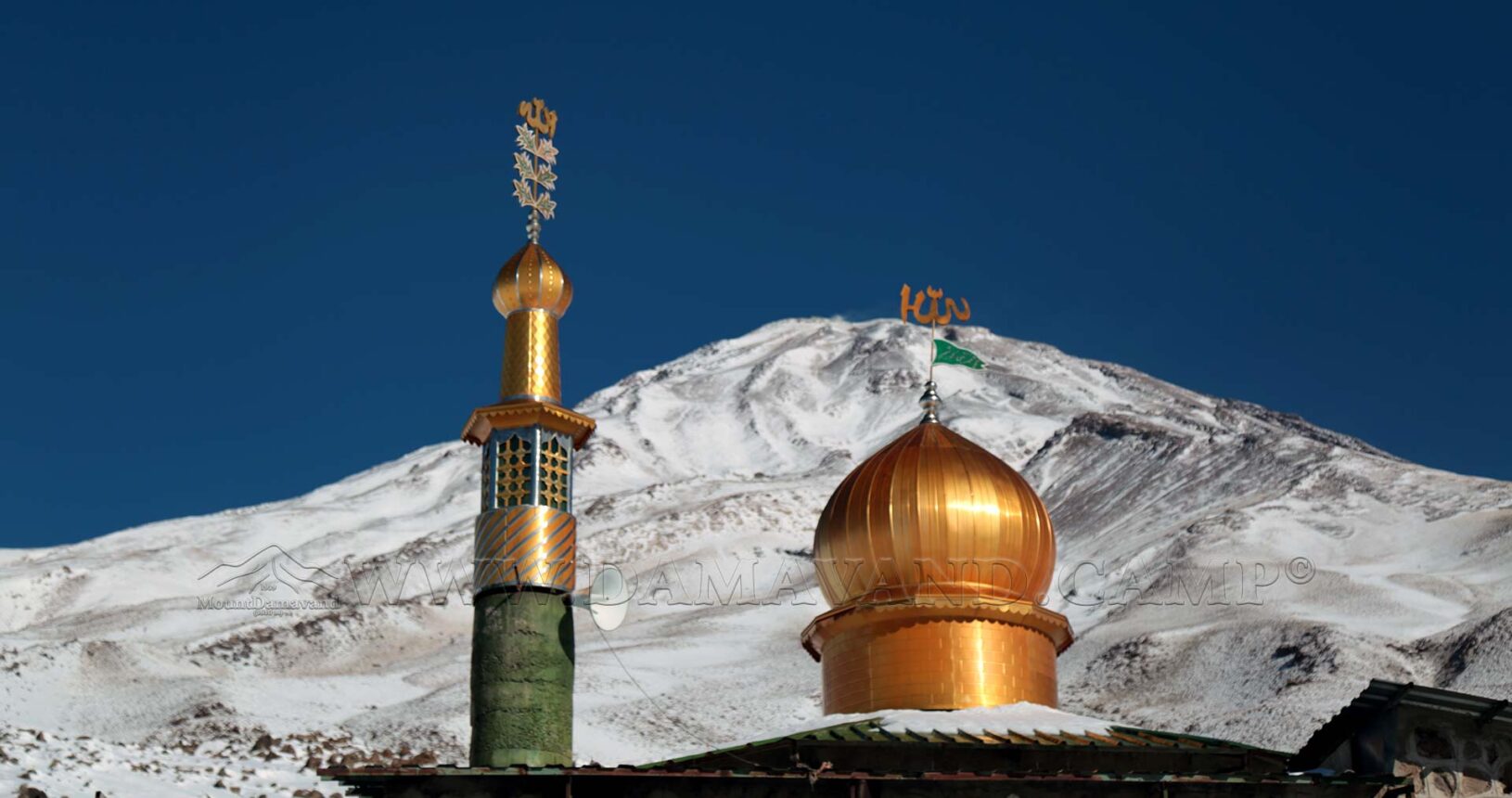 The snow covered Damavand behind the mosque at Camp II of Mount Damavand.